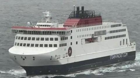 The Manxman ferry, which is painted in white, red and black on choppy waters. it has Steam-Packet.com and the firm's logo on the side.