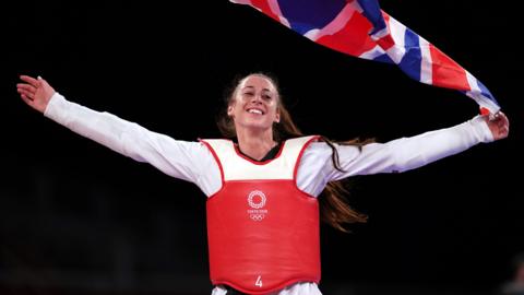 Bianca Walkden celebrating with the Union flag after securing a bronze medal