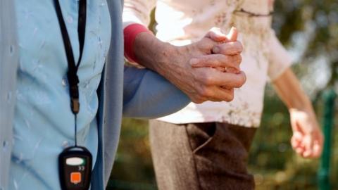 A resident of Foxholes Care Home in Hitchin, Hertfordshire, talks a walk amid the coronavirus pandemic