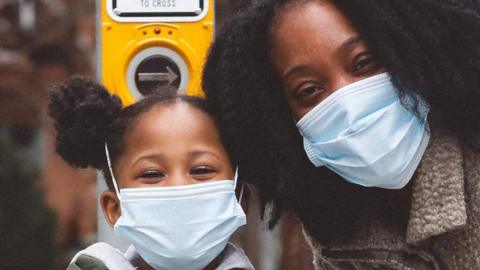 Mother and daughter smiling behind their masks