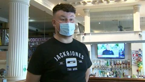 man wearing mask inside bar