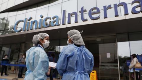 Health personnel stand outside of a private clinic after the last-minute agreement reached between the Government and private clinics to reduce health care prices during the pandemic, in Lima, Peru, 25 June 2020