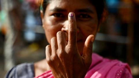 A woman shows her inked finger after casting her ballot to vote at a polling station as voting starts in the first phase of India's general election at the Dugeli village of Dantewada district, in the country's Chhattisgarh state on April 19, 2024.