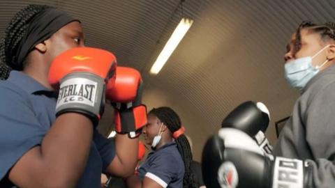 Two young girls sparring with boxing gloves