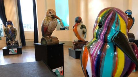 Several of the colourful kingfisher sculptures on display in the auction house