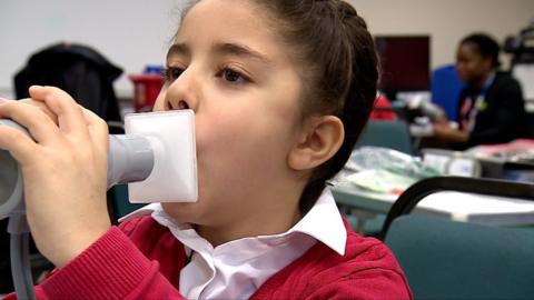 Child blowing into tube