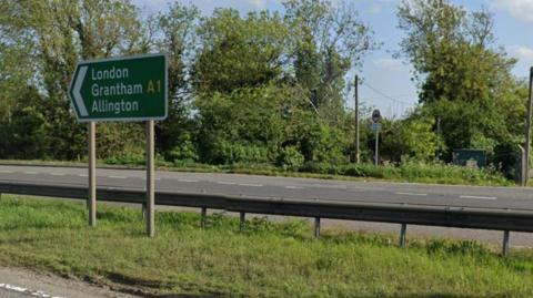 Green sign with white writing directing motorists towards Grantham and London