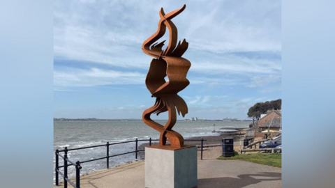The CGI design for the installation, on a plinth, with the sea in front of it