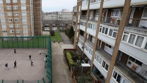 Children play a game of football in front of a residential development in the London borough of Tower Hamlets