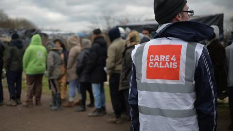 A general view of daily life in the Jungle refugee camp in Calais, France, with a worker wearing a Care4Calais top.