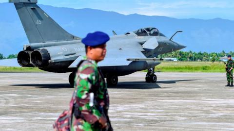 Indonesian soldiers stand guard near a French Rafale fighter jet at an air force base in Blang Bintang, Aceh province, on 19 May