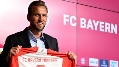 Harry Kane holds up Bayern Munich shirt