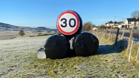 30mph speed sign on hay bales in field