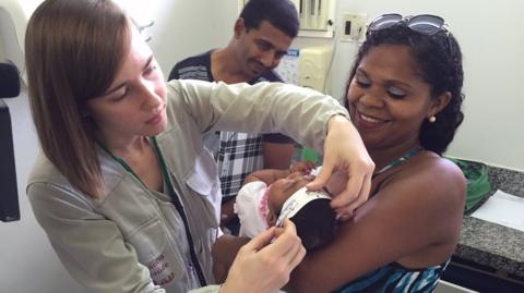 Doctors measure the head of a baby in Paraiba