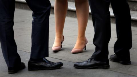 Stock image of men and a woman standing together