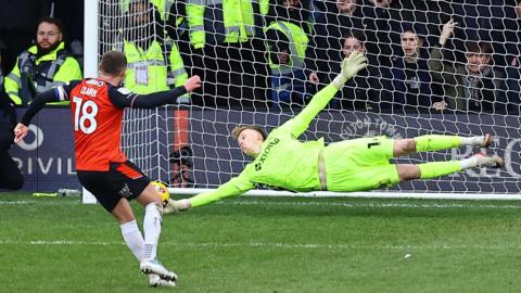 Luton's Jordan Clark sees his penalty saved by Stevenage goalkeeper Filip Marschall, diving low to his right