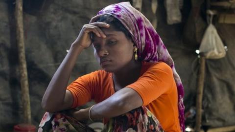 A Rohingya woman in the makeshift house she shares with 6 other refugees at a refugee camp in Cox's Bazar, Bangladesh.