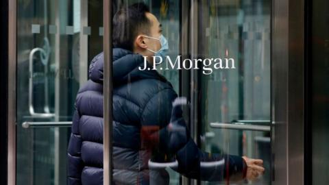 A worker entering JP Morgan offices in New York in March