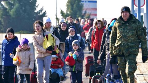 Ukrainian women and children cross the border from Ukraine to Poland at the Korczowa-Krakovets border crossing on 26 February 2022