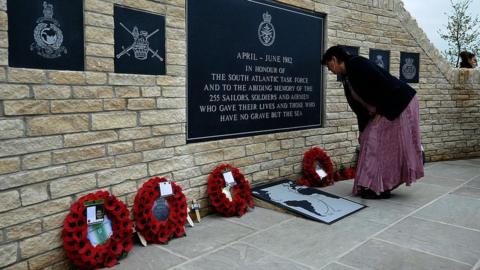 A woman lays a wreath after a dedication ceremony of the Falklands Memorial at the National Memorial Arboretum on 20 May 2012