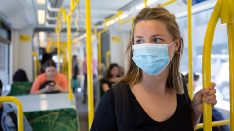 person on public transport wearing mask