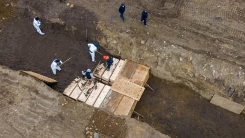 Drone pictures show bodies being buried in a wide trench on New York's Hart Island