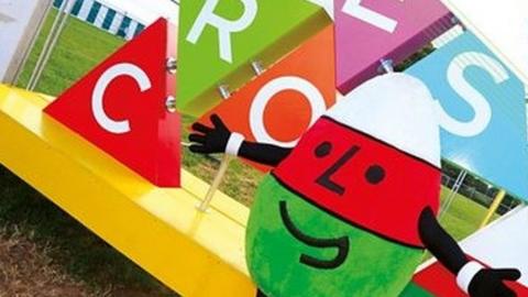 Urdd mascot Mr Urdd standing in front of a croeso (welcome) installation