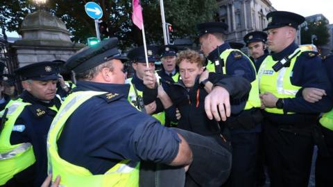 Police remove a protester during an Extinction Rebellion demonstration in Dublin