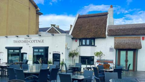 Picture of the Old Thatched Cottage restaurant with blue sky