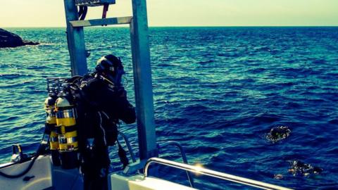 A diver prepares to enter the water to investigate the site of La Girona wreck