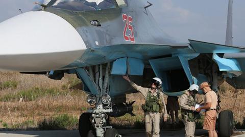 The Russian pilots of a Su-34 strike fighter check their aircraft at the Hmeymim airbase, outside Latakia, Syria.