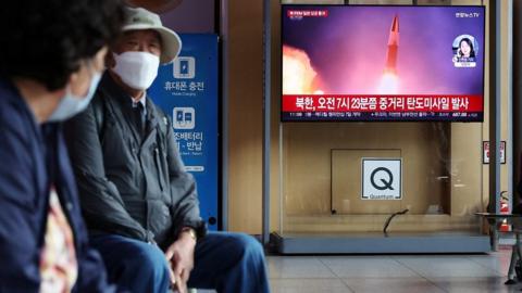 People in Japan - missile launch on TV screen