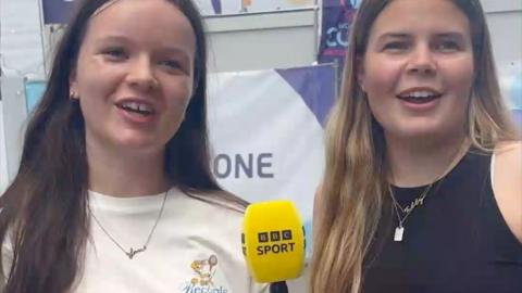 Two women looking into camera and holding BBC Sport-branded microphone
