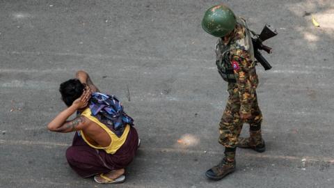 Man sits on floor next to soldier