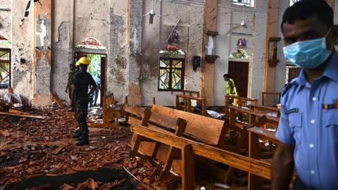 Security officials inspect the interior of St Sebastian's Church in Negombo on April 22, 2019