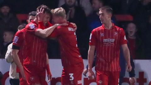 Cheltenham players celebrate a goal against Oxford