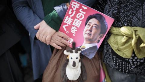 Hand holding Shinzo Abe campaign leaflet