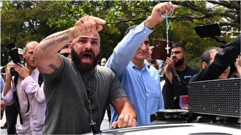 Pro Catholic supporters yell during a protest