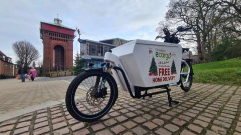 An eCargo delivery bike in front of Jumbo water tower and the Mercury Theatre in Colchester