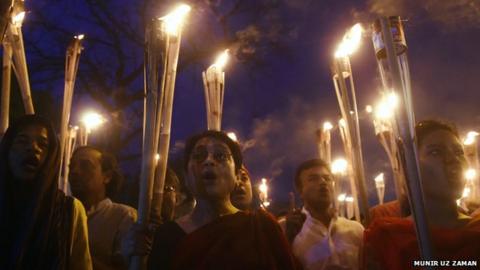 Mourners in Dhaka hold burning torches as they mourn killing of blogger Avijit Joy
