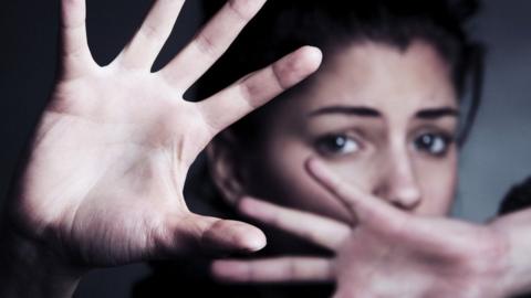 Woman shielding her face with her hands