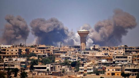 Smoke rises from a rebel-held area in the Syrian city of Deraa after a reported government air strike on 5 July 2018