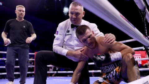 Referee Bob Williams holds Connor Coghill after stopping the fight with Hopey Price