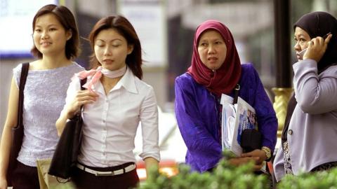 Women walk down the street in Kuala Lumpur