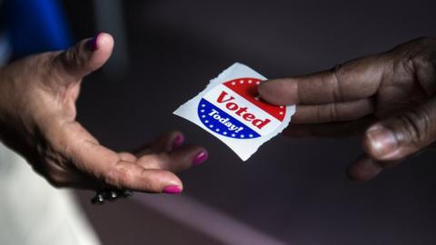 handing a voting sticker