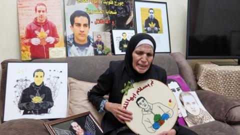 Rana Halaq holds up a picture of her son Iyad Halaq at her home in occupied East Jerusalem, following the Israeli court verdict acquitting the Israeli border police officer who killed him in May 2020