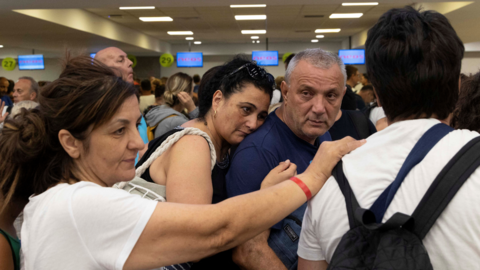 Holidaymakers queue at airport after being evacuated from Rhodes