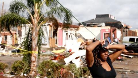 A woman looks at the wreckage caused by a tornado in New Orleans, Louisiana.