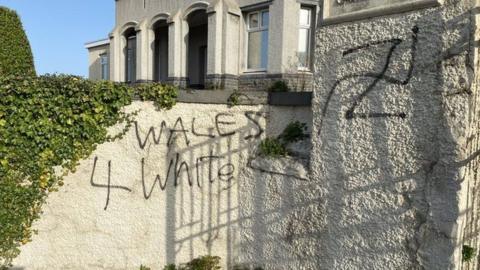 Graffiti hiliol a'r swastika gafodd ei baentio ar waliau'r Cyngor Llyfrau yn ddiweddar