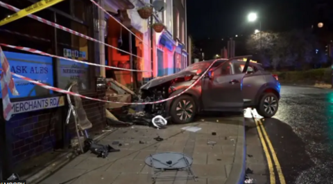 Black car crashed into front of pub with police tap around at night.